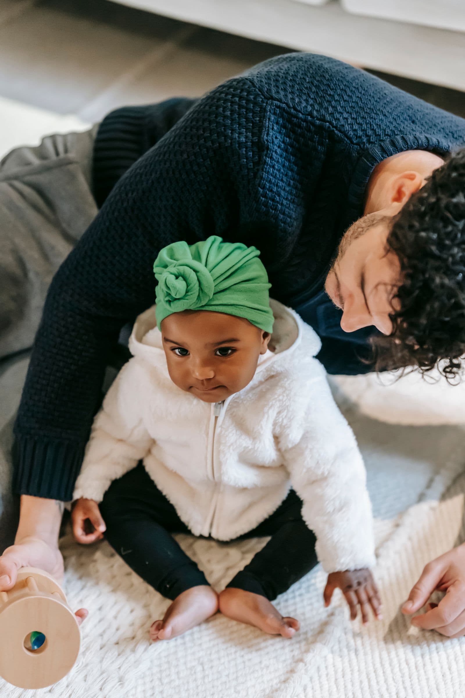 A father playing with his little daughter on the living room floor