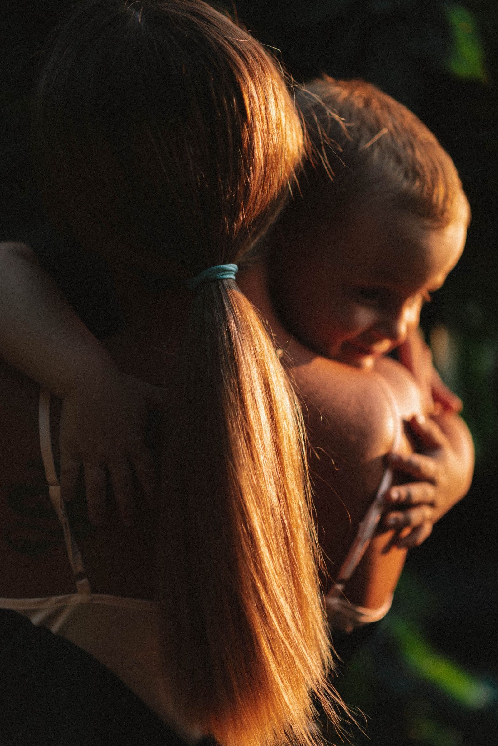 A mother and child hugging in warm evening light
